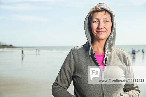Woman on beach in hooded top  Folkestone  UK