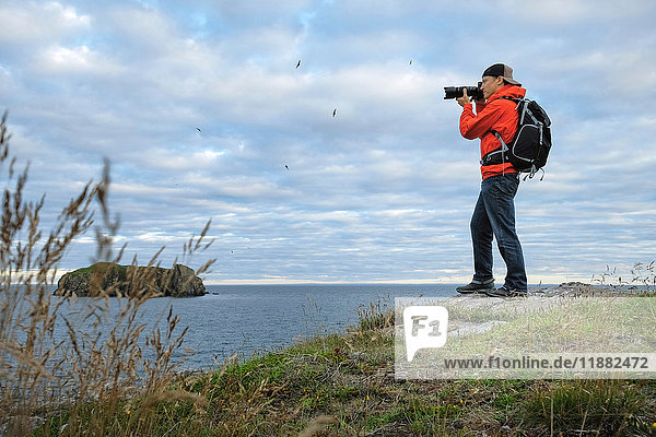 Mittelgroßer erwachsener Mann beim Fotografieren der Küstenlinie  Saint John  Kanada