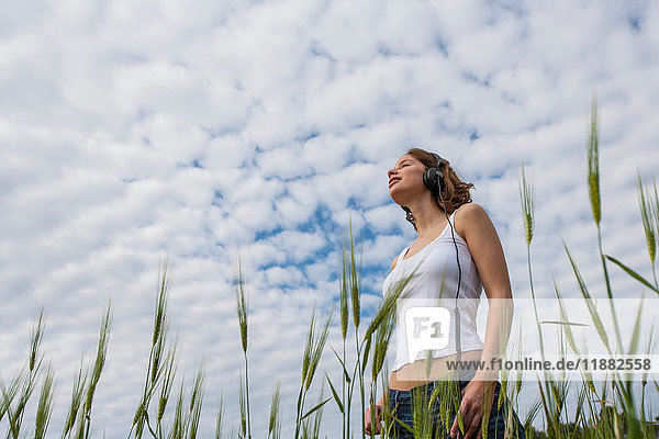 Frau im Feld unter flauschiger Wolke  die wegschaut  Palma de Mallorca  Balearen  Spanien  Europa