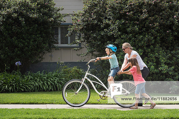 Junge auf der Straße lernt Fahrrad fahren