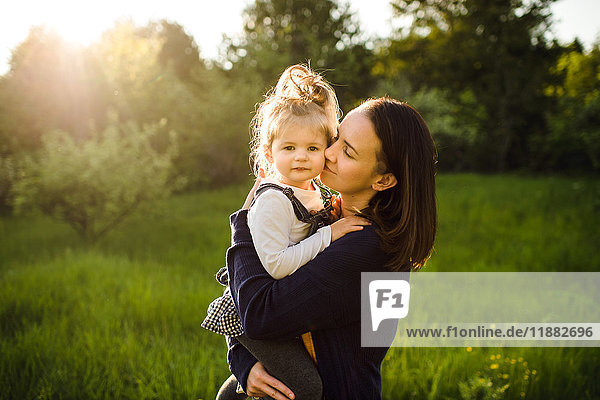 Bildnis einer Frau  die ihre Tochter im Sonnenlicht küsst