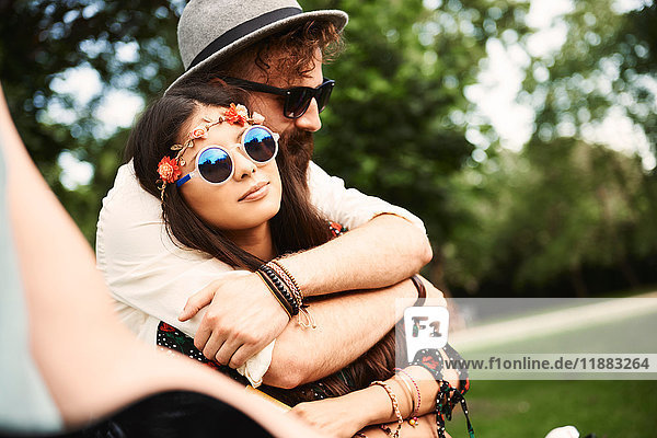 Romantisches junges Boho-Paar umarmt sich beim Festival