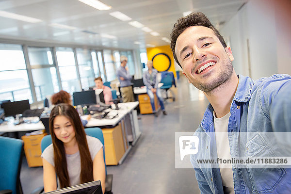 Male digital designer taking selfie in office