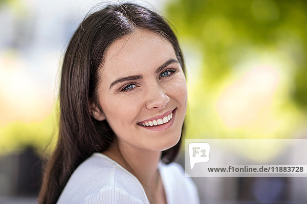 Porträt einer jungen Frau  im Freien  lächelnd