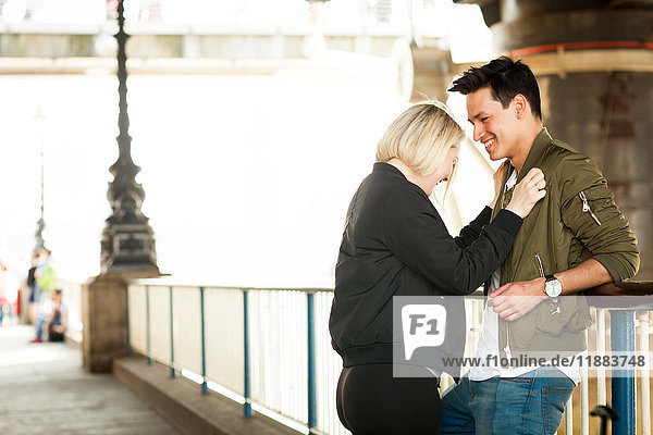 Junges Paar  unter der Brücke stehend  von Angesicht zu Angesicht  lachend