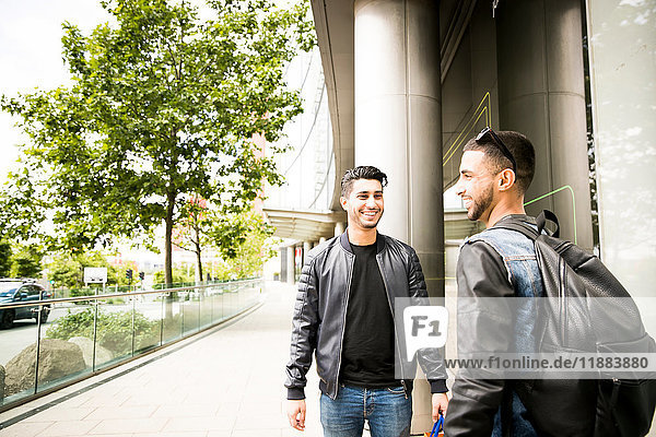 Two young men  standing in street  smiling