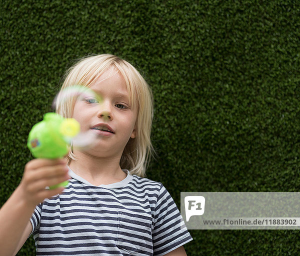 Boy blowing bubble with bubble maker
