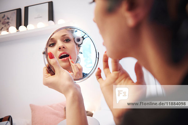 Spiegelbild einer Frau  die Lippenstift aufträgt