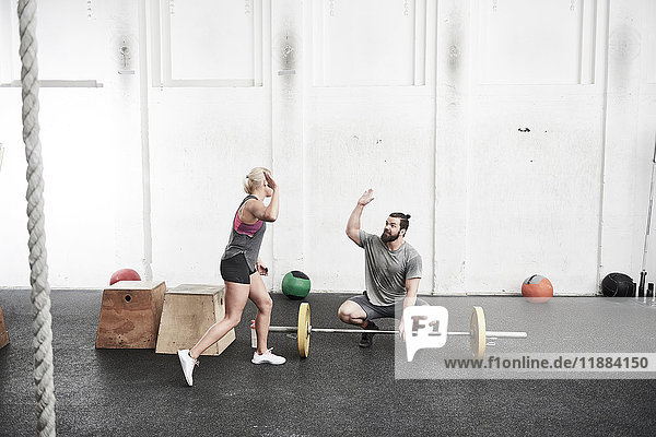 Couple giving high five in cross training gym