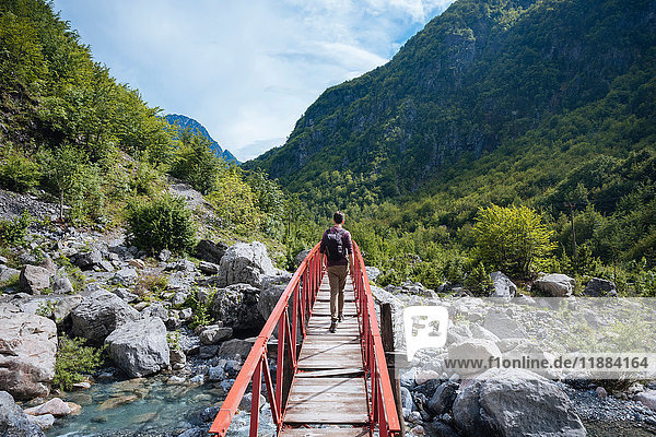 Rear view of man crossing bridge  Accursed mountains  Theth  Shkoder  Albania  Europe