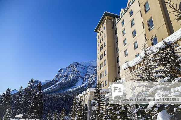 Blick von der Seite auf die schneebedeckten Berge und das Fairmont Chateau Lake Louise Resort Hotel in den Rocky Mountains; Lake Louise  Alberta  Kanada '