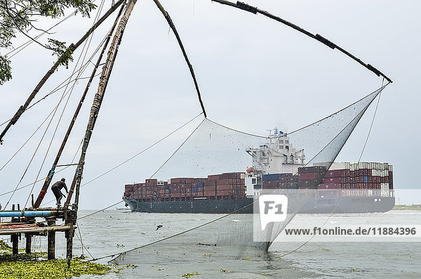 'Chinese fishing nets with container ship in background; Kochi  Ernakulam district  Kerala  India'