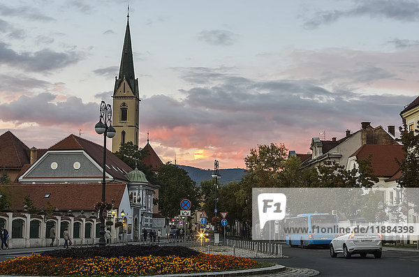 'View of the old town with roundabout with flowers  car and bus at dusk; Zagreb  Croatia'