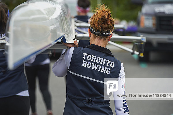 Die Frauenmannschaft der Universität Toronto trägt ihr Boot bei der Regatta Head of the Trent zu Wasser; Ontario  Kanada'.
