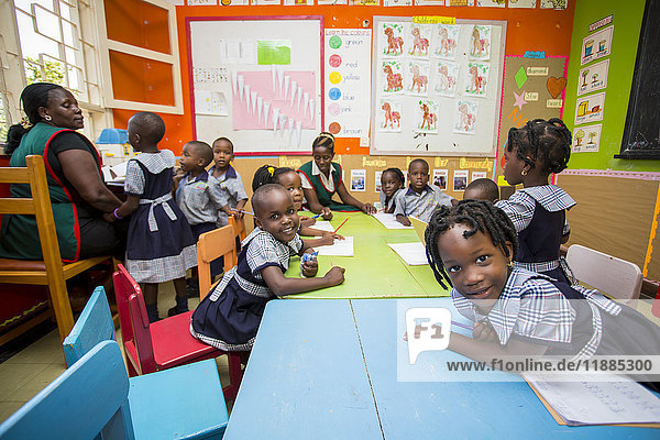 Kleine Kinder in einem Klassenzimmer mit einer Lehrerin in der Treasures Christian Preschool; Kampala  Uganda'.