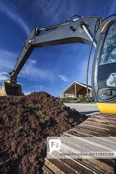 'An excavator digs up soil outside Lakemount Church; Grimsby  Ontario  Canada'