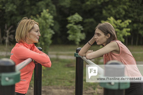 Seitenansicht von Mutter und Tochter am Geländer im Park