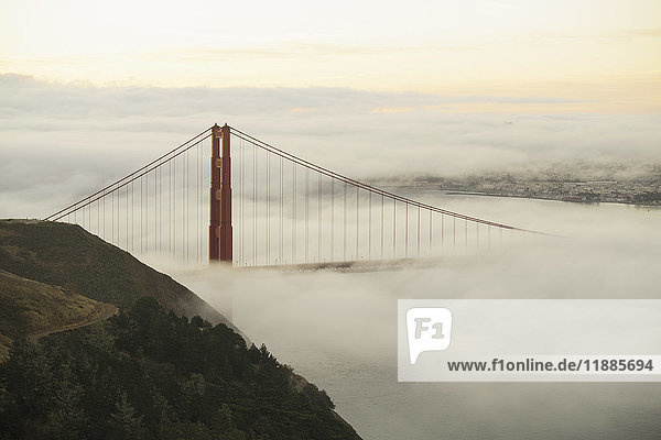 Golden Gate Bridge umgeben von Nebel über der San Francisco Bay bei Sonnenuntergang  Kalifornien  USA