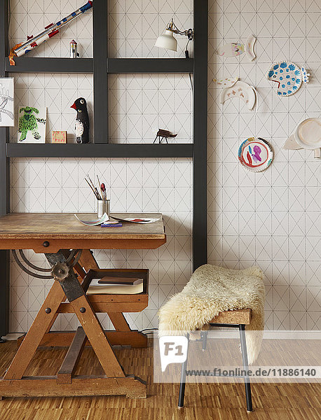 Holztisch unter den Regalen an der Wand zu Hause