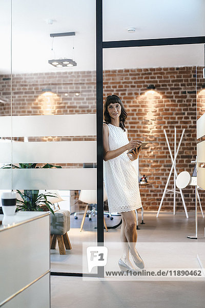 Businesswoman standing in office  holding digital tablet