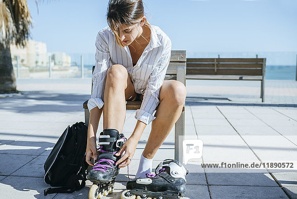 Young woman putting on inline skates