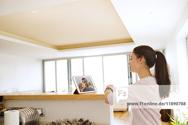 Young woman using tablet for video chat at home