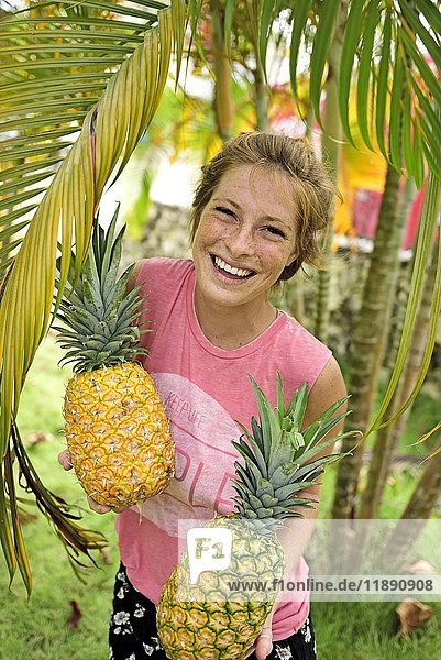 Dominikanische Republik  Porträt einer lachenden jungen Frau mit Ananas