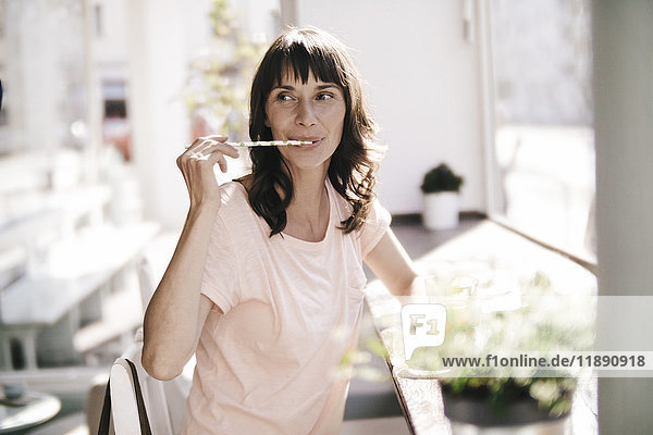Woman sitting cafe  licking a drinking straw