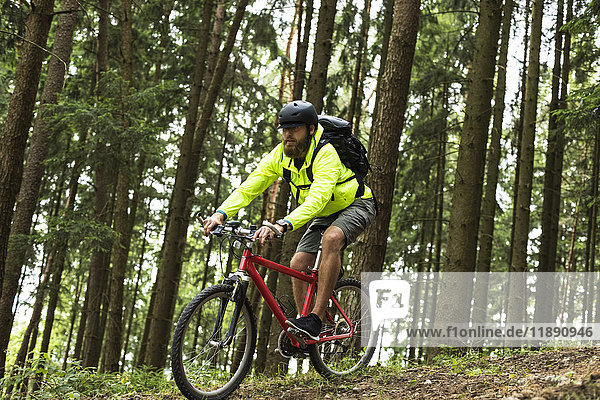 Man mountain biking in forest