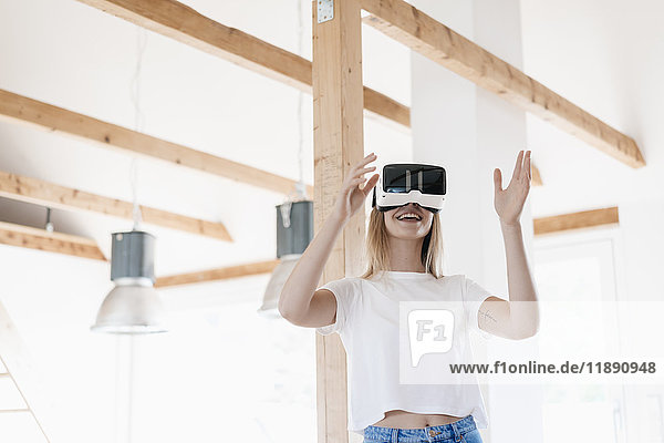 Young woman wearing VR goggles  designing her new home