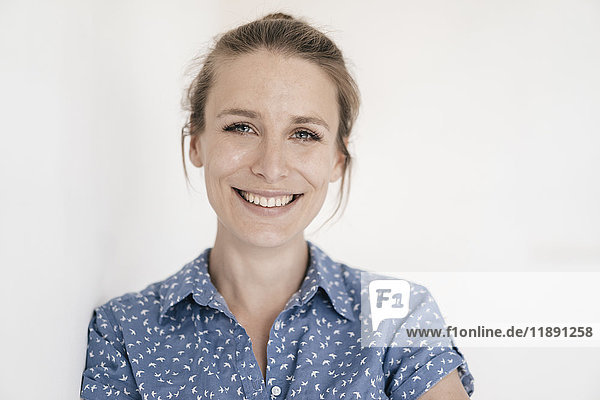 Porträt einer lächelnden Frau vor weißem Hintergrund