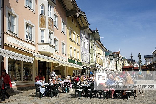 Menschen sitzen in einem Café vor einer Reihe historischer Häuser  Marktstraße  Bad Tolz  Oberbayern  Bayern  Deutschland  Europa