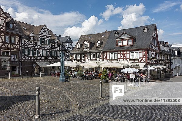 Marktplatz mit Fachwerkhäusern und historischer Wasserpumpe  Gäste im Cafe unter Sonnenschirmen  Braunfels  Hessen  Deutschland  Europa