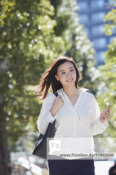 Japanese woman walking in city park in Tokyo