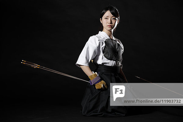 Japanese traditional archery athlete against black background