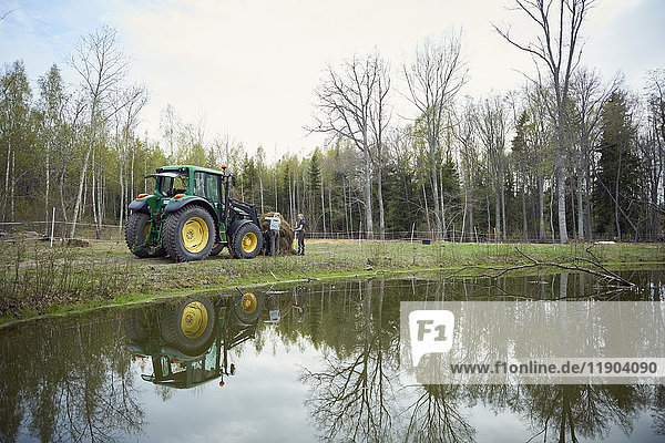 Farmers with tractor at lakeshore
