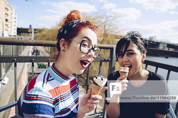 Porträt von Hipster-Freundinnen beim Eis essen in der Stadt