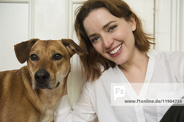 Porträt einer lächelnden kaukasischen Frau und eines Hundes