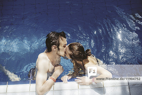 Caucasian couple kissing in swimming pool