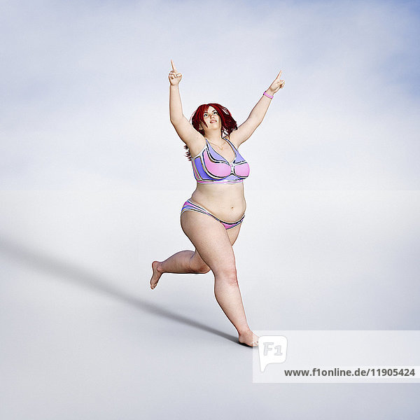 Übergewichtige Frau läuft im Bikini