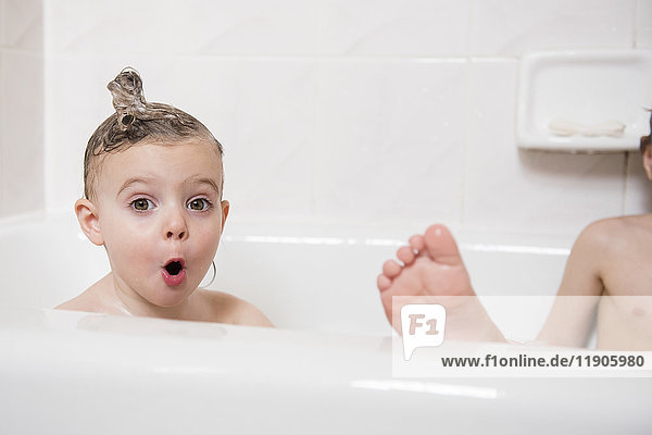Surprised Caucasian girl in bubble bath