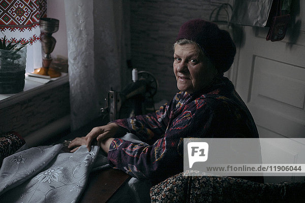 Older Caucasian woman using sewing machine