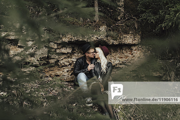 Affectionate Middle Eastern couple kissing near rocks