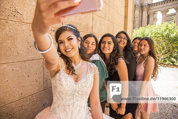 Hispanic girls posing for cell phone selfie