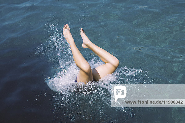 Caucasian teenage girl diving into water