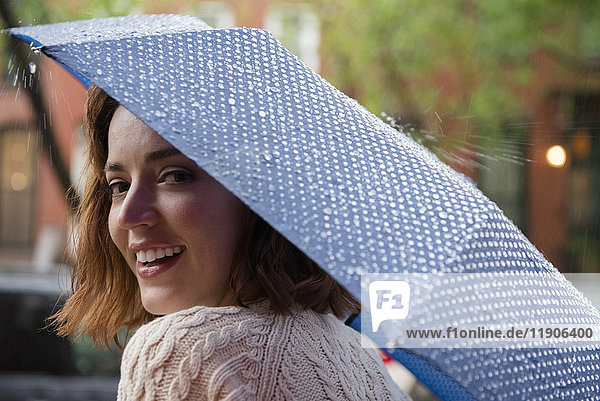 Porträt einer lächelnden kaukasischen Frau mit Regenschirm