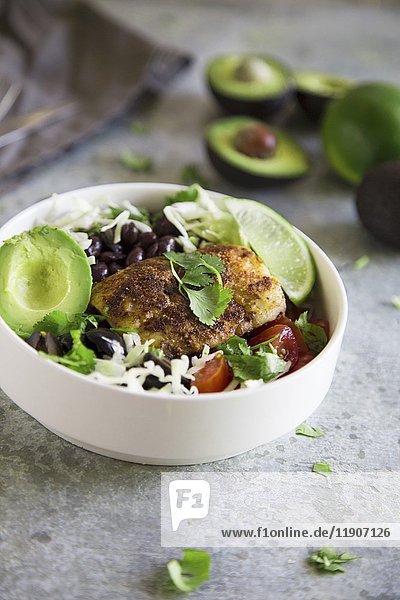 Taco Bowl with fish  avocado and black beans and white cabbage