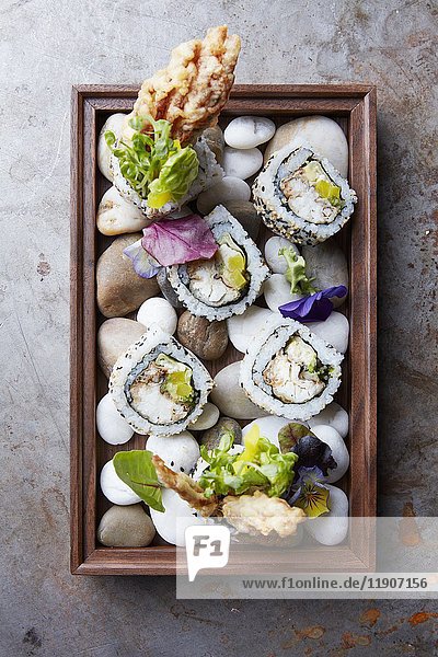 California rolls served on a wooden tray with stones (Japan)
