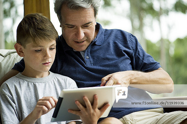 Mann mit Kind mit digitalem Tablett