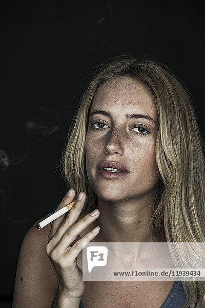 Junge Frau raucht Zigarette  Porträt